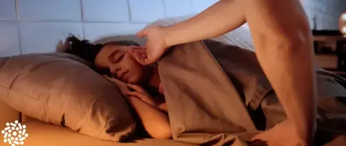 Criança com febre dorme enquanto um adulto checa a temperatura do rosto com a mão